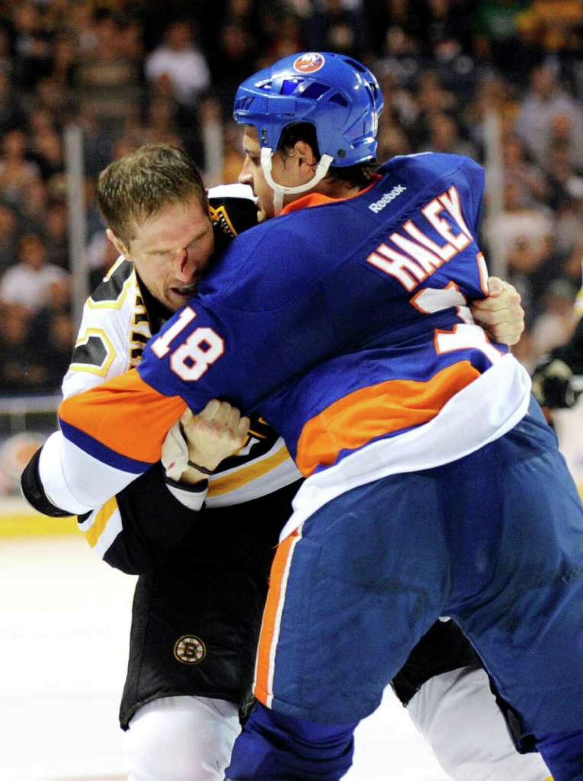 Boston Bruins' Chris Clark, left, fights with New York Islanders' Michael Haley (18) during the second period of a preseason NHL hockey game in Bridgeport, Conn., on Saturday, Oct. 1, 2011. The Bruins won the game 3-2. (AP Photo/Fred Beckham)