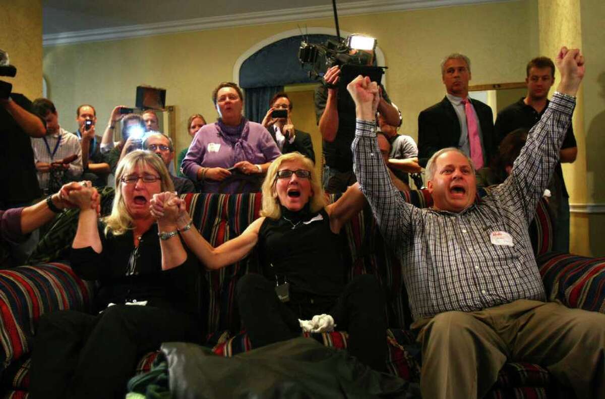 From left, supporters of Amanda Knox Kellanne Henry, Margaret Ralph, and Joe Starr, celebrate during the reading of the verdict as supporters of Amanda Knox gather on Monday at the Fairmont Olympic Hotel in Seattle. The supporters gathered to hear a verdict in the Knox murder trial in Italy.