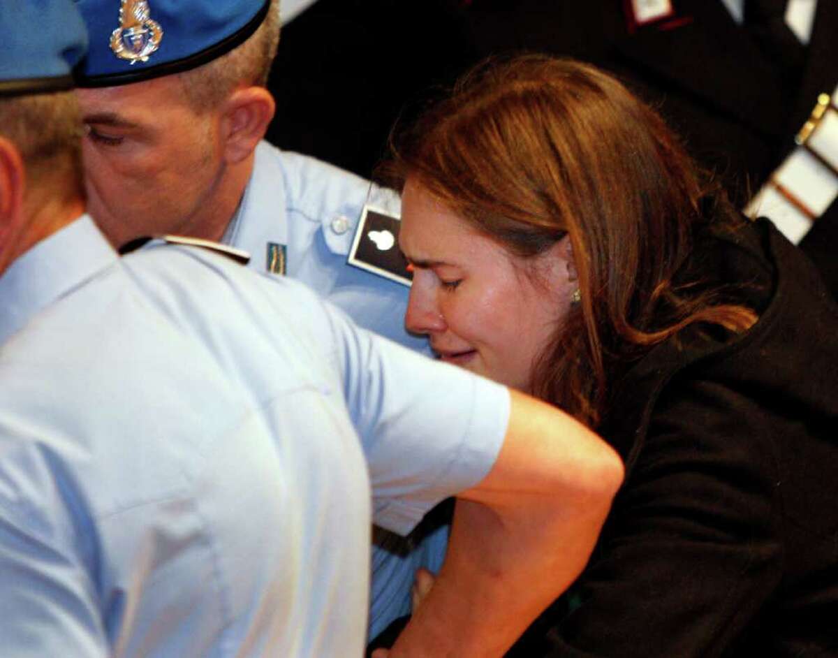 Amanda Knox breaks in tears as she is taken away after hearing the verdict that overturns her conviction and acquits her of murdering her British roommate Meredith Kercher, at the Perugia court, central Italy, Monday, Oct. 3, 2011. Italian appeals court threw out Amanda Knox's murder conviction Monday and ordered the young American freed after nearly four years in prison for the death of her British roommate. Knox collapsed in tears after the verdict overturning her 2009 conviction was read out. Her co-defendant, Italian Raffaele Sollecito, also was cleared of killing 21-year-old Meredith Kercher in 2007.(AP Photo/Pier Paolo Cito)