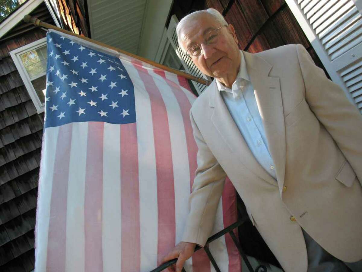 Emil "Bennie" Benvenuto stands by the flag at his North Mianus home in this 2010 file photo. Benvenuto, an anchor of the Greenwich GOP who was blackballed by his party for his support of Lowell Weicker Jr., died early Tuesday morning. He was 80. Benvenuto had been suffering from prostate cancer, according to friends. Elected to the 151st District in the state House of Representatives in 1976, serving six terms, Benvenuto then captured the 36th District in the Senate. He served for two years before a split among local Republicans saw him lose to William Nickerson in 1990.
