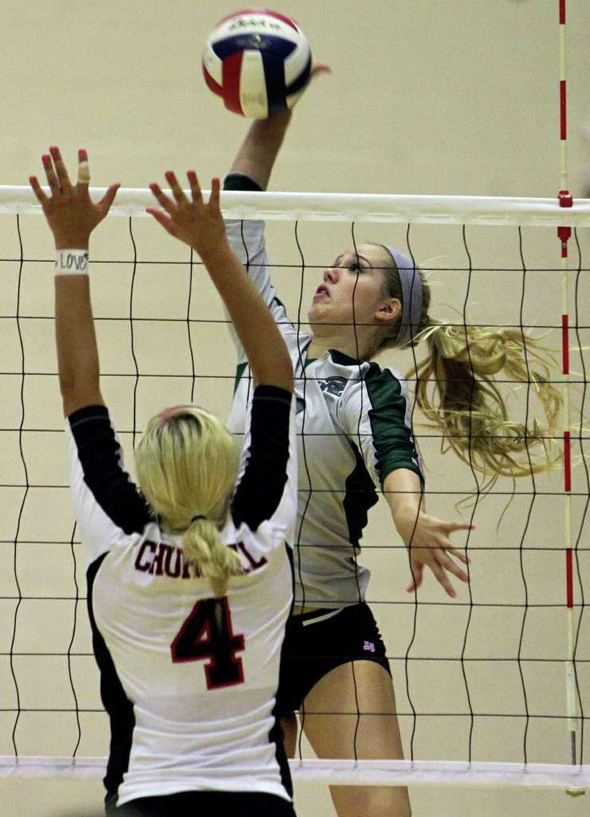 Reagan’s Bailey Shurbet goes for a kill over Churchill’s Jordan Holub (4) as the Rattlers win in three games Tuesday, Oct. 4, 2011 at Littleton Gym.