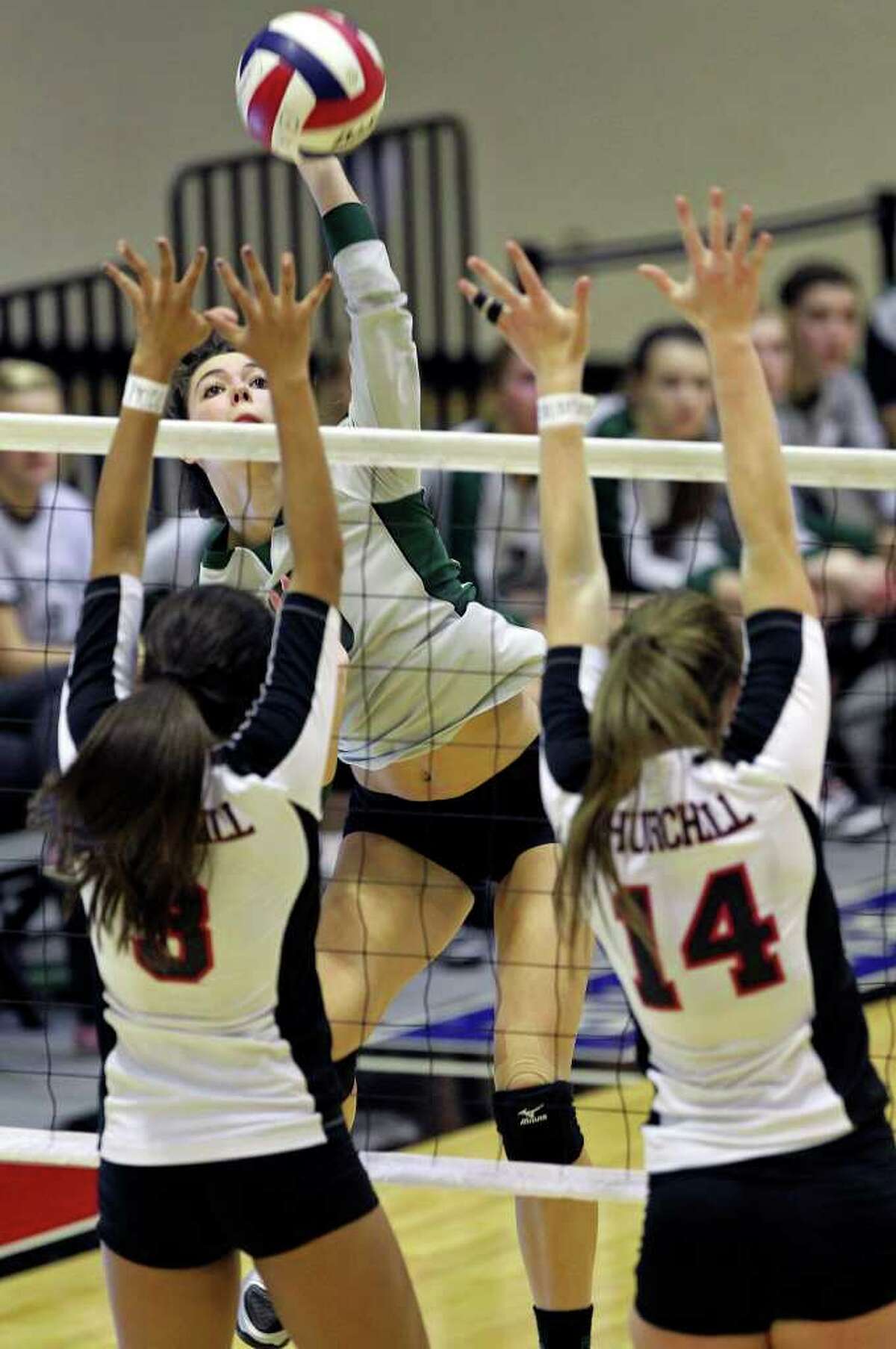 Reagan’s Dayna Kramer takes a shot over Churchill’s Tori Guerra (3) and Audrey Sanders as the Rattlers win in three games Tuesday, Oct. 4, 2011 at Littleton Gym.