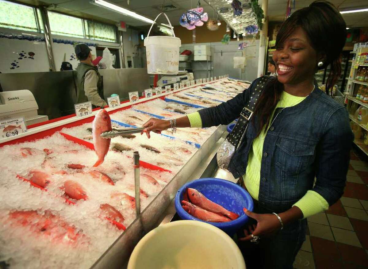 Devon Rutherford of Bridgeport shops for fresh fish at the International Farmers Market on Main Street in Bridgeport. Rutherford travels to the market twice a month by city bus.