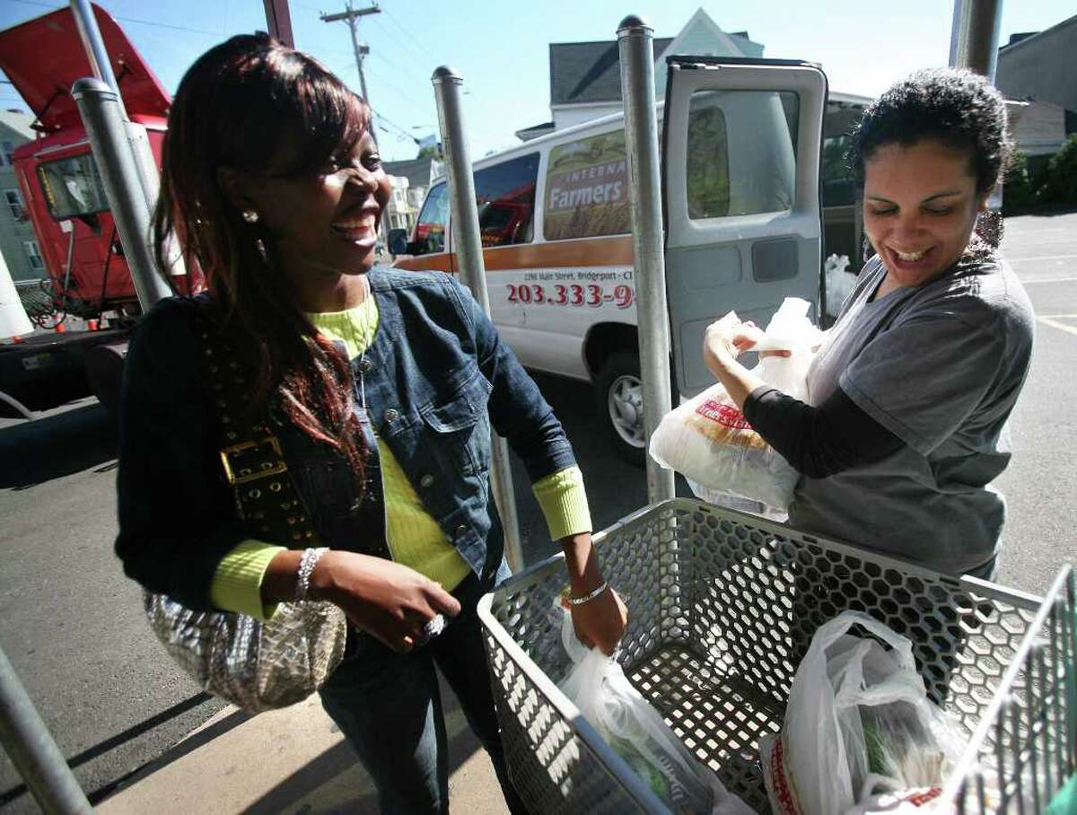 Devon Rutherford, left of Bridgeport gets help loading her groceries into a shuttle by driver Marlene Bryant at the International Farmers Market on Main Street in Bridgeport. The store drives shoppers and their groceries to their homes if they spend a minimum of one hundred dollars.