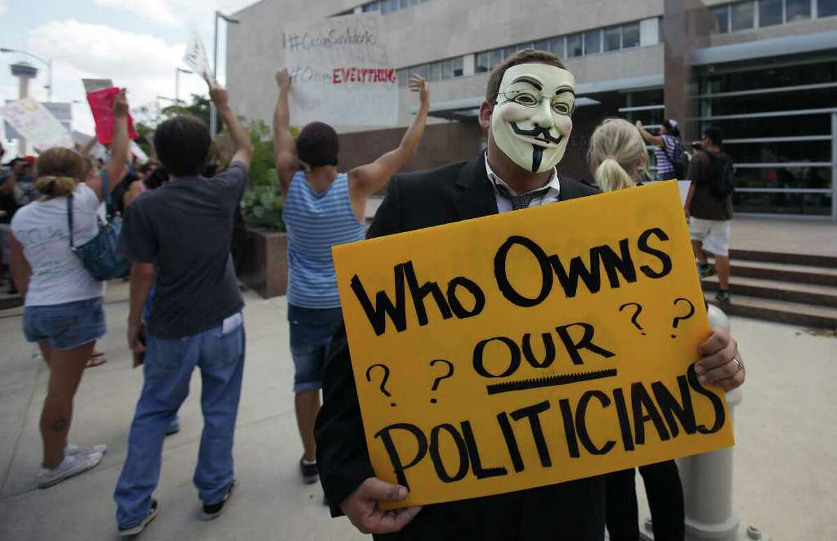 A protester holds a sign questioning the integrity of politicians in front of the Federal Reserve office in San Antonio on Thursday, Oct. 6, 2011. In support of the protesters at New York's Wall Street demonstration, about 100 people in San Antonio gathered to voice their opposition to the current financial state of affairs. The demonstrators gathered at Travis Park and marched toward the Federal Reserve office and around Main Plaza. No arrests or confrontations were witnessed at the mostly peaceful yet loud protest. Kin Man Hui/kmhui@express-news.net