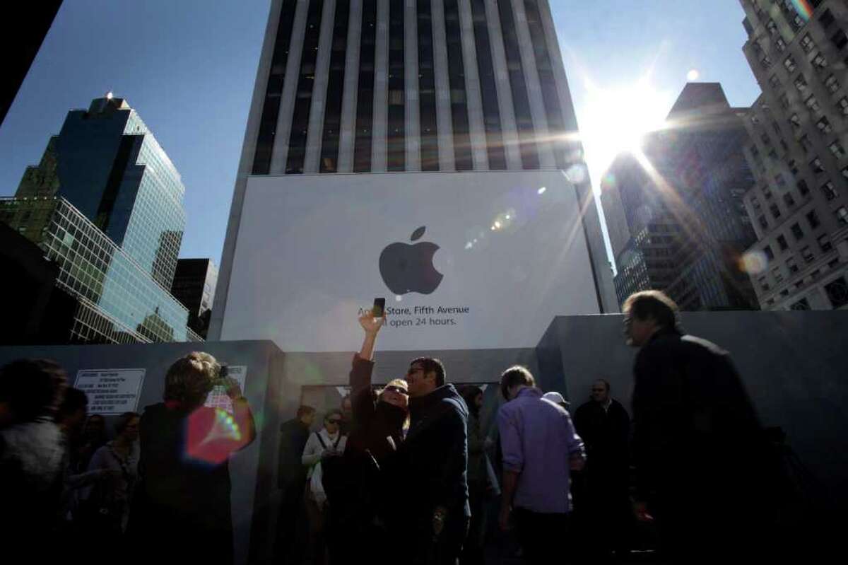 Stephen Yang : Bloomberg APPLE IN THE BIG APPLE: New Yorkers use iPhones to photograph signs outside of an Apple Store on Thursday. Steve Jobs, who built the world's most valuable technology company by creating devices that changed how people use electronics, died Wednesday.