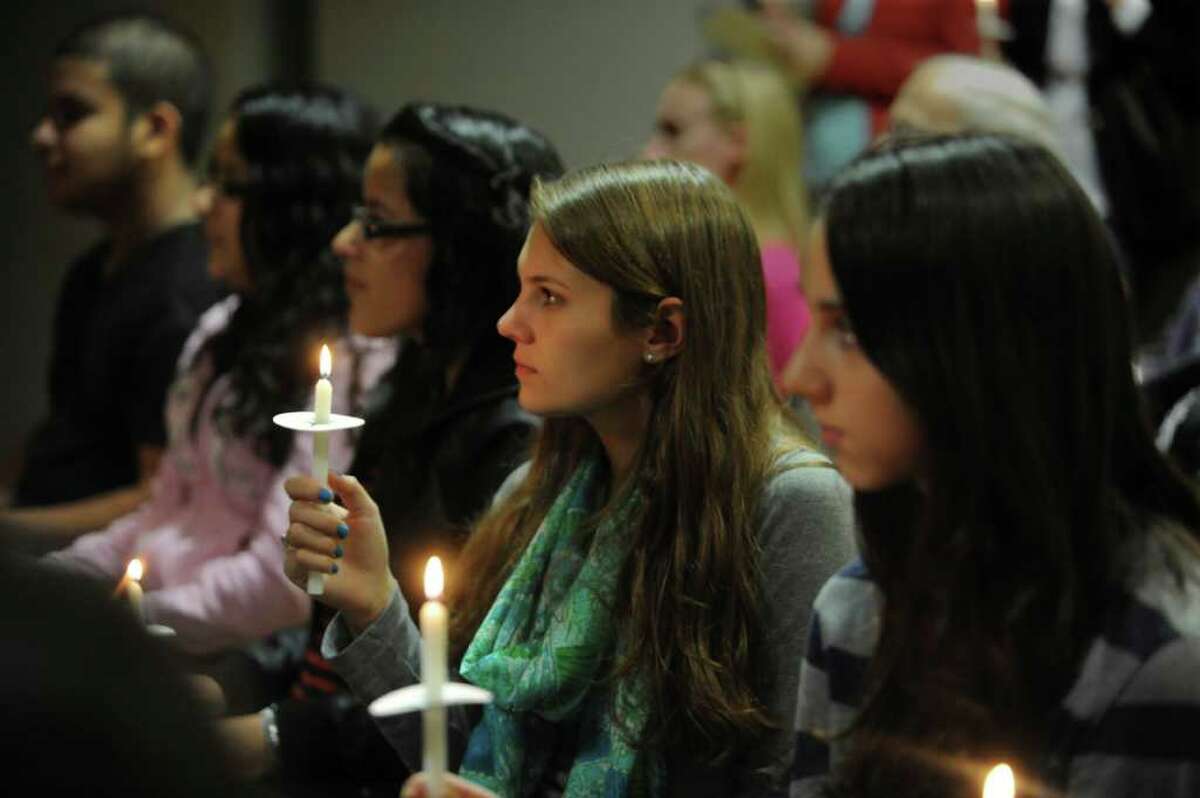 Kerrin Kinnear, second from right, holds a candle at the YWCA Domestic Abuse Services' annual candlelight vigil Thursday, Oct. 6, 2011.
