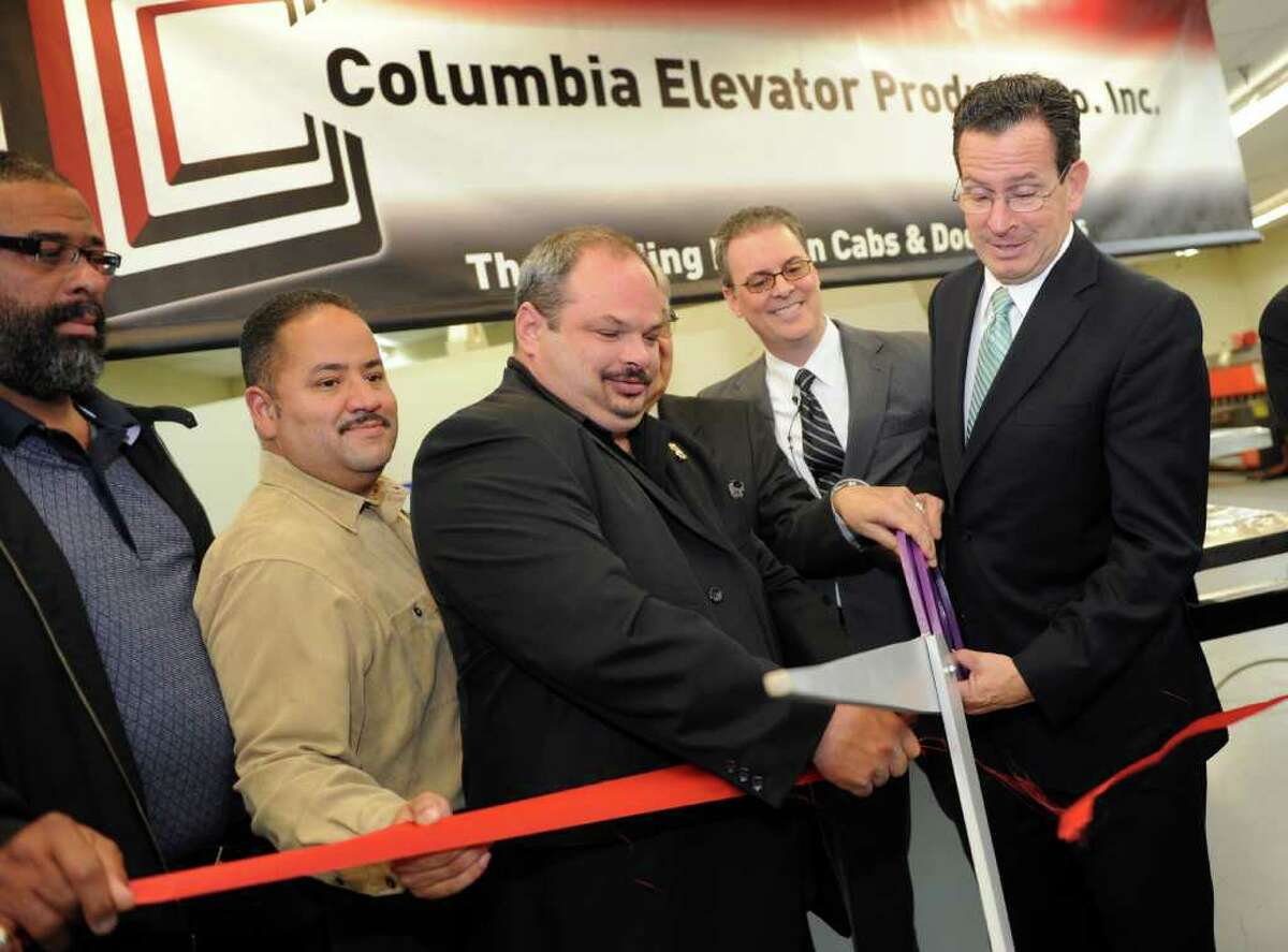 Governor Dannel P. Malloy cuts the ribbon to mark the relocation of Columbia Elevator Co. to Bridgeport during a ceremony Friday, Oct. 7, 2011. From left, state Rep. Charles "Don" Clemons Jr., state Rep. Andres Ayala, City Council member Richard Paoletta and LJ Blaiotta, CEO and president of Columbia Elevator Co., help with the cutting.