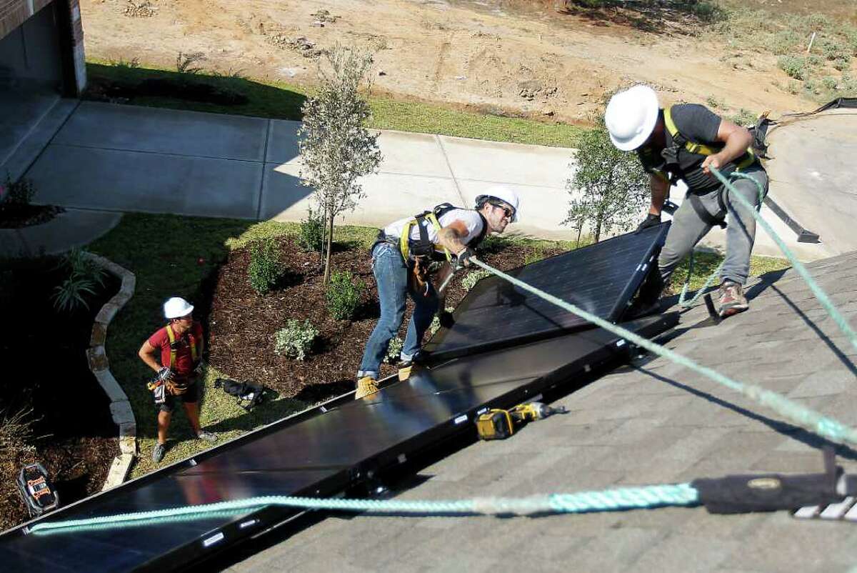 Richard Sherwood, right, co-owner of Adaptive Solar Design of Houston, and Danny Furness install a roof panel on a home in The Woodlands. The solar energy industry in Texas is undeterred by recent manufacturing failures elsewhere.