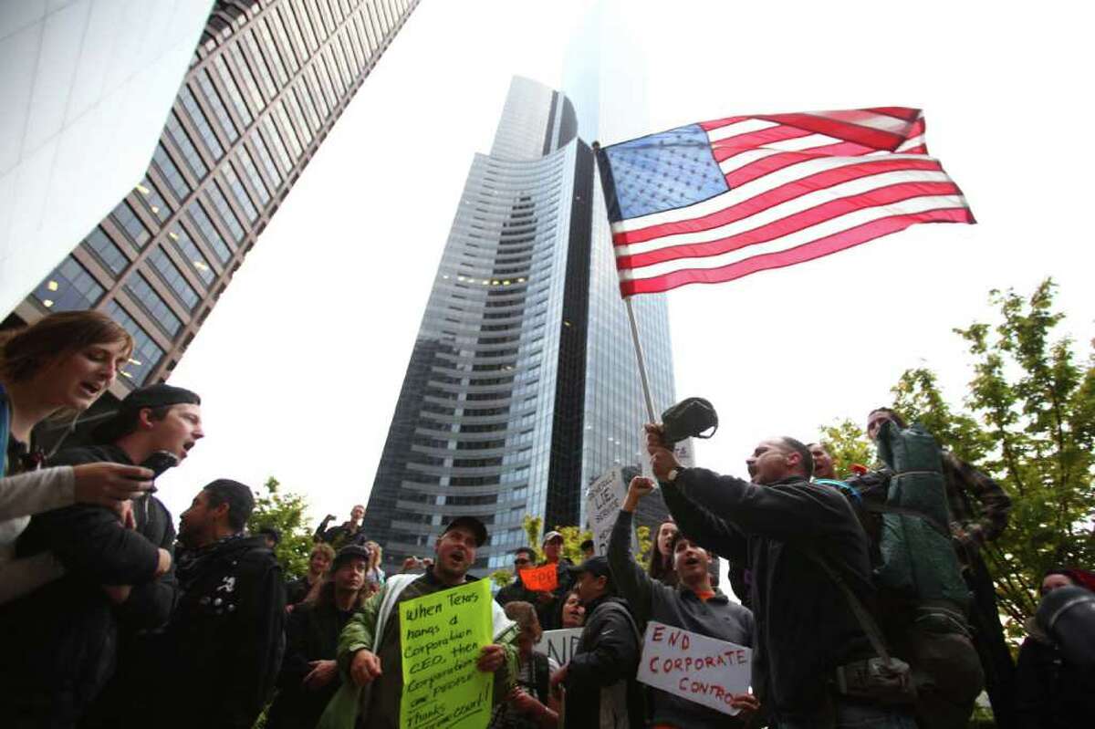 Chris Beiter, right, leads protesters in singing the Star Spangled Banner as Occupy Seattle protesters take to the streets of downtown Seattle during the second week of the local protest held in solidarity with the Occupy Wall Street protest in New York City. The marchers gathered at Bank of America Fifth Avenue Plaza and for a short time occupied a downtown intersection.