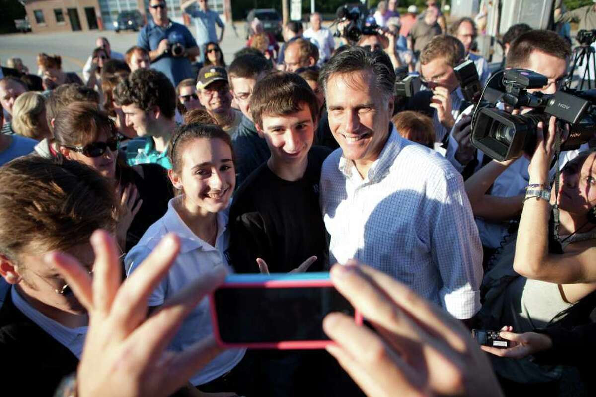 HOOKSETT, NH - OCTOBER 10: GOP presidential candidate Mitt Romney poses for a picture with supporters outside Robie's Country Store, October 10, 2011 in Hooksett, New Hampshire. Romney and the rest of the crowded field of GOP candidates will square off in a debate tomorrow night at Dartmouth College. (Photo by Matthew Cavanaugh/Getty Images)