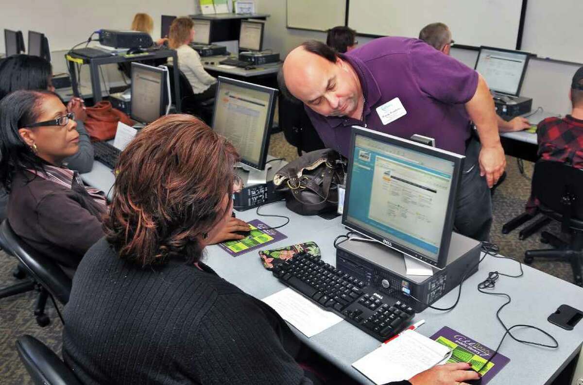 Metrix class instructor Wayne Pombrio (standing) of Albany City youth and workforce services conducts computer training in the Albany Public Library's computer lab in September 2010. (John Carl D'Annibale / Times Union)