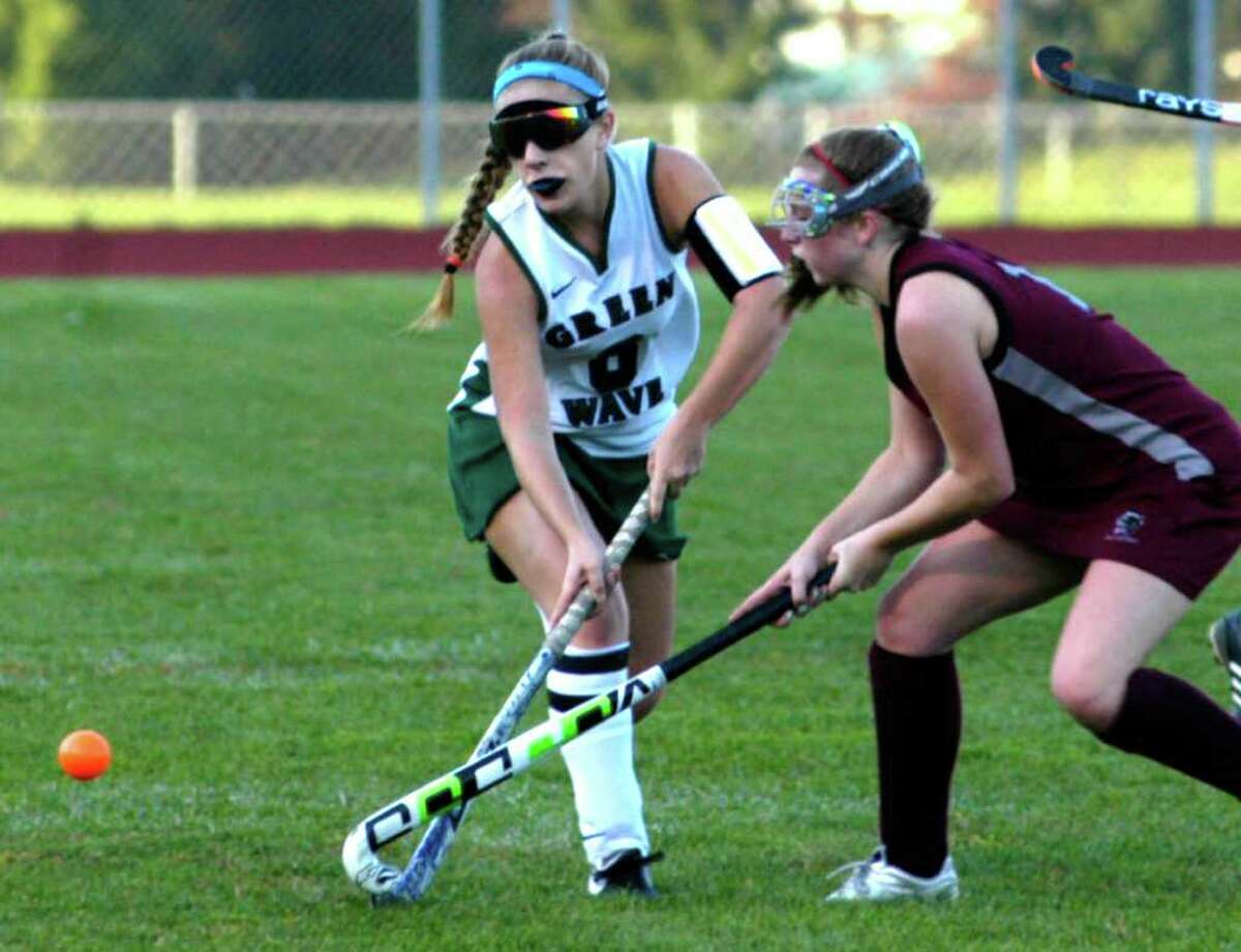 SPECTRUM/Gabby Scocca advances a pass to a Green Wave teammate despite the efforts of a Pomperaug player during New Millford High School field hockey's 1-1 deadlock with the Panthers, Oct. 7, 2011 at NMHS