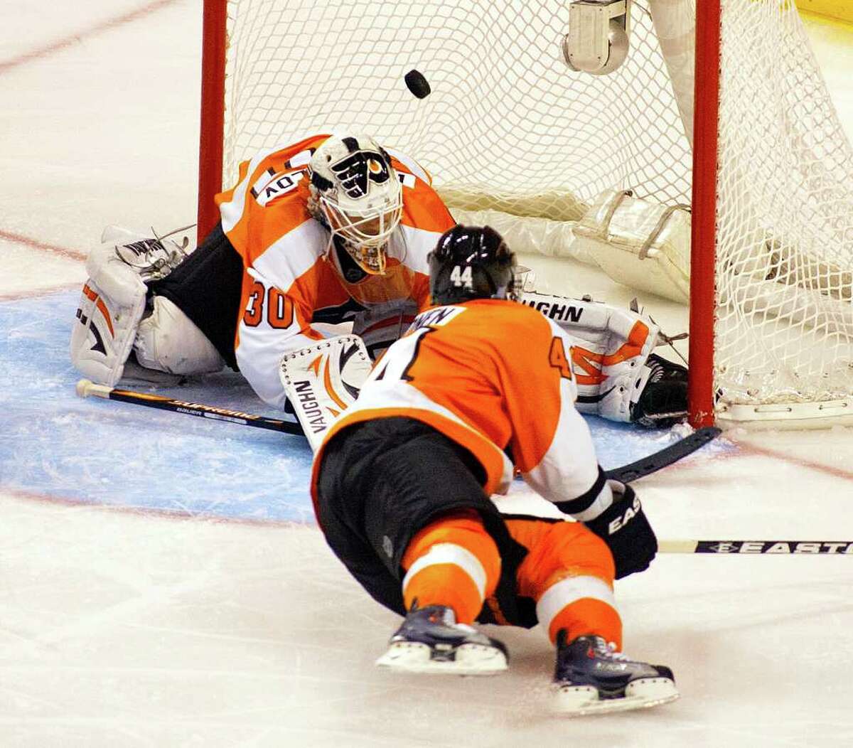A wrist shot by Vancouver Canucks Daniel Sedin, not pictured, sails past Philadelphia Flyers Kimmo Timonen and goalie Ilya Bryzgalov to tie the score during the third period of an NHL hockey game, Wednesday, Oct. 12, 2011, in Philadelphia. The Flyers won 5-4. (AP Photo/Tom Mihalek)