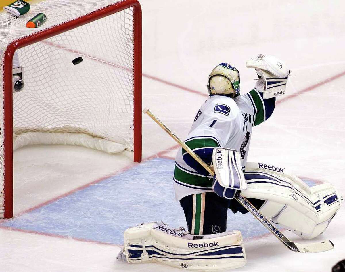 Vancouver Canucks' Roberto Luongo looks over his shoulder as the game-winning goal shot by Philadelphia Flyers Andrej Meszaros flies past him into the net during the third period of an NHL hockey game, Wednesday, Oct. 12, 2011, in Philadelphia. The Flyers won 5-4. (AP Photo/Tom Mihalek)