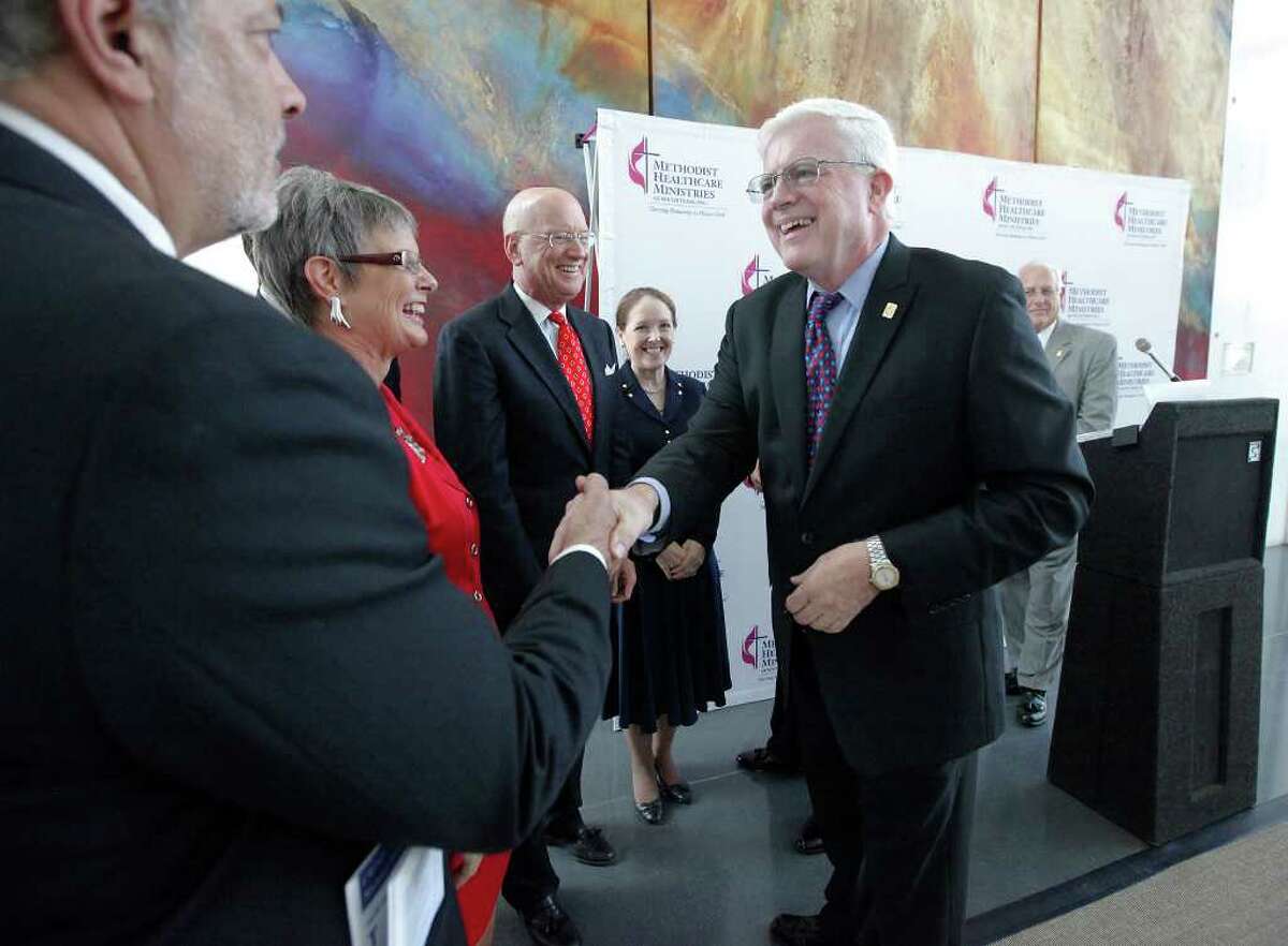 Kevin C. Moriarty (right), the president and CEO of Methodist Healthcare Ministries, shakes hands after announcing the almost $10 million gift.