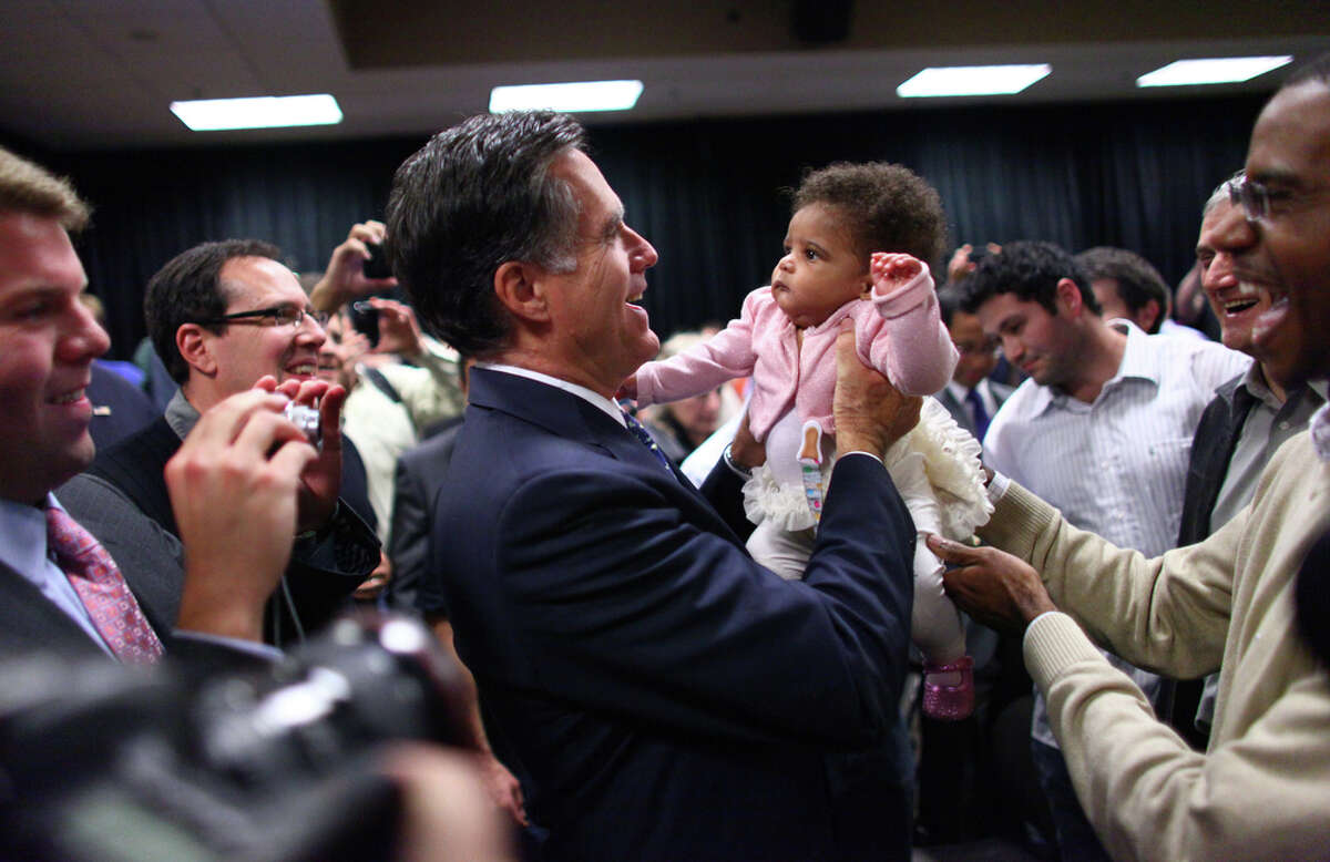 Presidential candidate Mitt Romney lifts Alexandria McDonald, 6 months, daughter of Microsoft employee Orville McDonald, far right, after a speech on Thursday, October 13, 2011 on the Microsoft campus in Redmond. The Republican presidential candidate came to Microsoft as part of a speaker series and talked about trade policy.