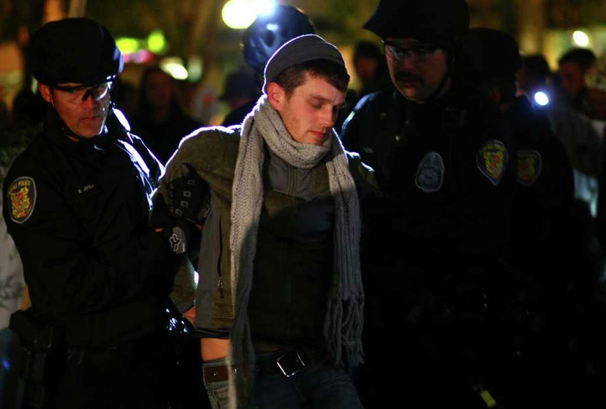 Seattle Police arrest an Occupy Seattle protester at Seattle's Westlake Park on Thursday, October 13, 2011. Ten protesters were arrested for refusing to move from a makeshift structure in the park. Earlier city officials said that people needed to clear from the park at 10 p.m. when it closes. Eventually police withdrew, causing the crowd gathered to erupt in cheers.