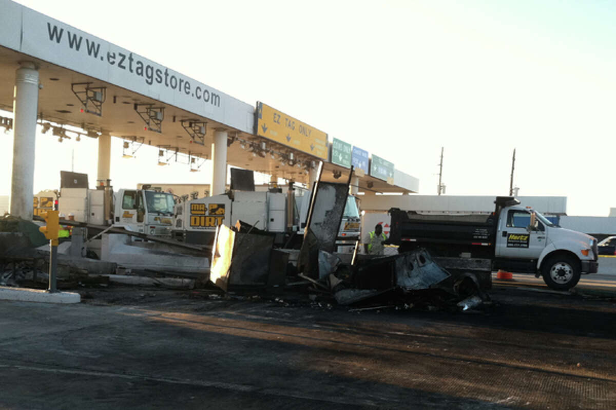 Officials work to clean up the burned up wreckage at the tollway plaza near Antoine on the North Beltway Friday morning. (Dale Lezon / Chronicle)