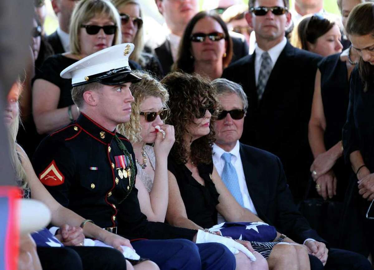 Becky Whetstone, at right, sits with an American flag during services for her son LCpl. Benjamin Schmidt at Sam Houston National Cemetery Friday Oct. 14, 2011. At left, Whetstone's daughter and the Schmidt's sister, Casey Schmidt, sits next to a U.S. Marine escort. At far right is John Cheairs. Schmidt was killed in action on October 6 while on patrol in Afghanistan. The 24-year-old was a graduate of Alamo Heights High School and attended Texas Christian University. He was stationed out of Camp Pendleton, California. Serving his second tour in Afghanistan, Schmidt deployed in September with the 2nd Battalion, 4th Marine Regiment.