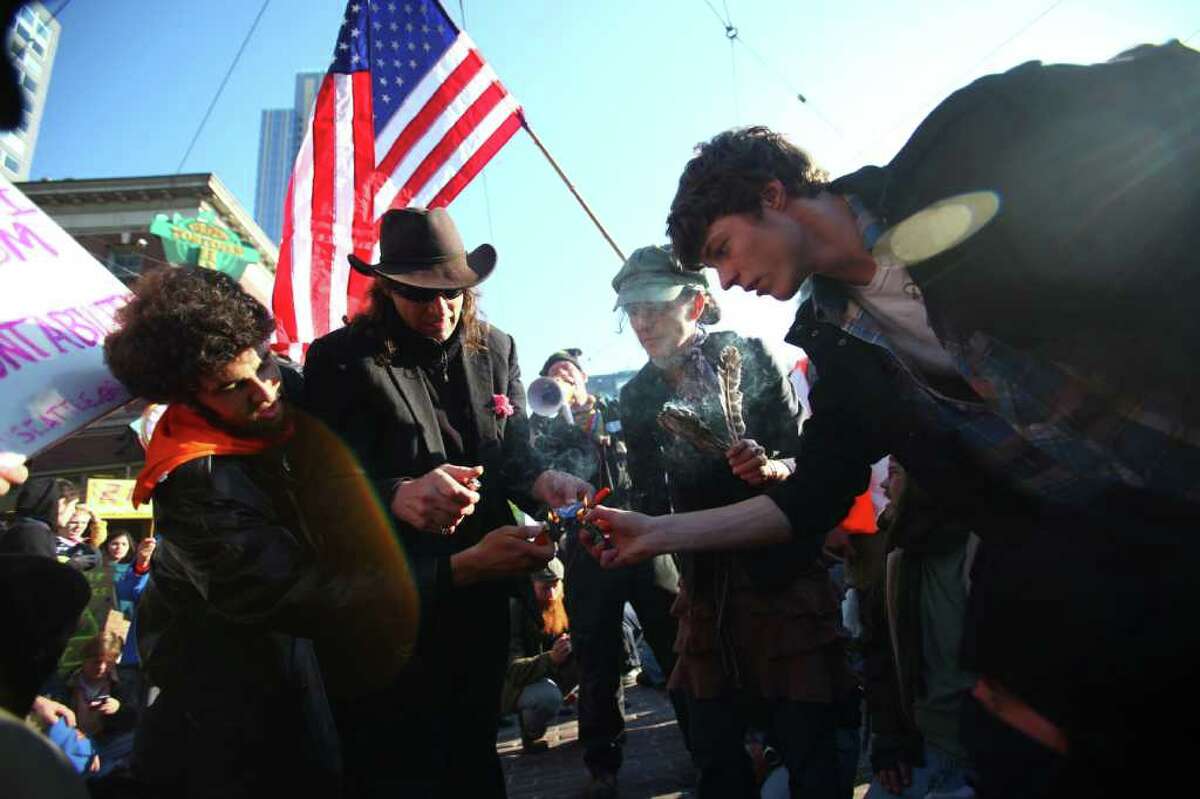 Occupy Seattle protesters burn credit and debit cards in front of Pike Place Market.
