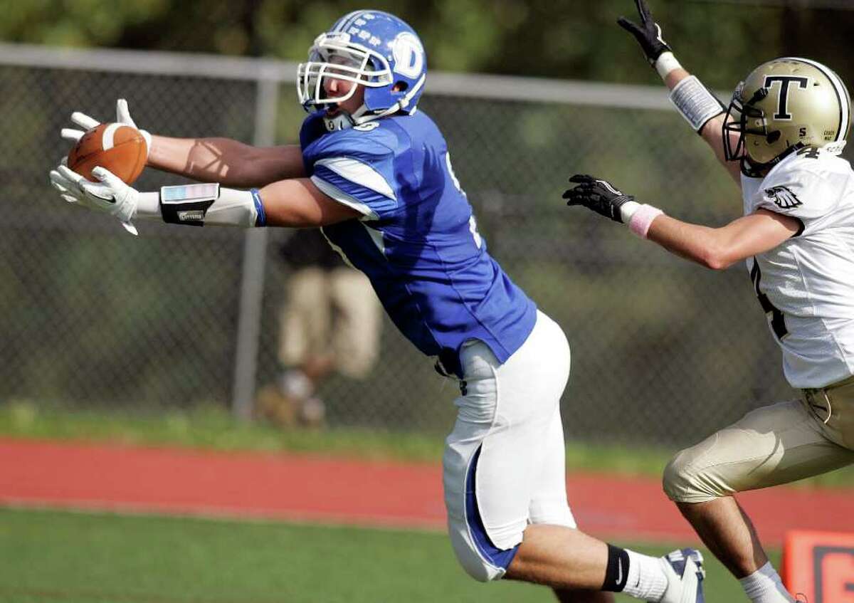 Darien wideout Matthew Forelli catches the first of his two touchdown receptions during an FCIAC battle against Trumbull High School on Saturday in Darien. Covering on the play is Jeff Jaboe. Darien won the game 21-0.