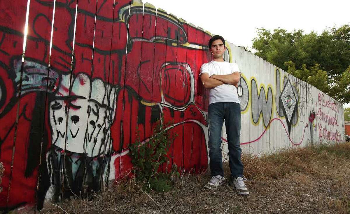 FOR METRO- Portrait of UTSA senior art major Alex Vela and the fence at his home which he and others have graffitied Friday Aug. 12, 2011.