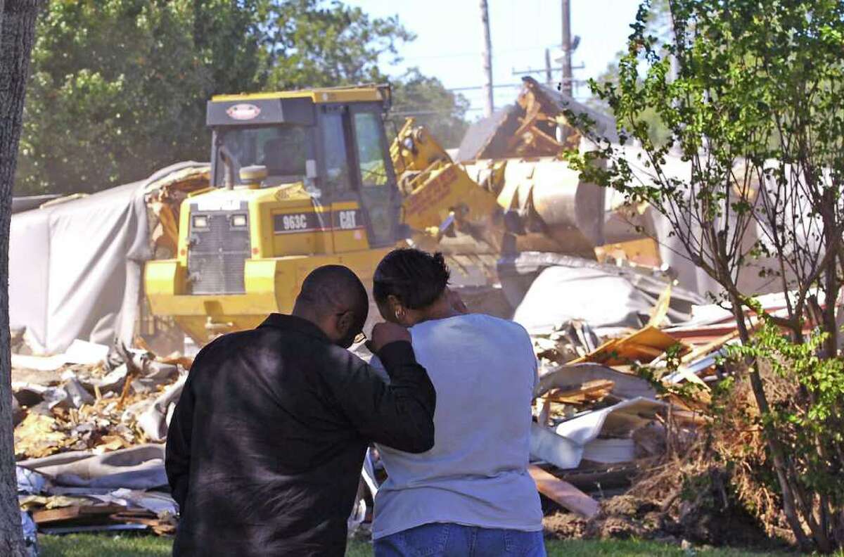 Apartment manager Renee Watts, right, and former resident Lionel Johnson, left, watch the demolition of building #1. Demolition continued Tuesday afternoon at the Beaumont Housing Authority's Lucas Gardens property. The former buildings were an apartment complex for older people operated by the Beaumont Housing Authority. It is currently being demolished and in its place, the housing authority will build a new property to be called The Crossing. The housing authority will be able to triple the available space fro senior citizens who are low income. Dave Ryan/The Enterprise