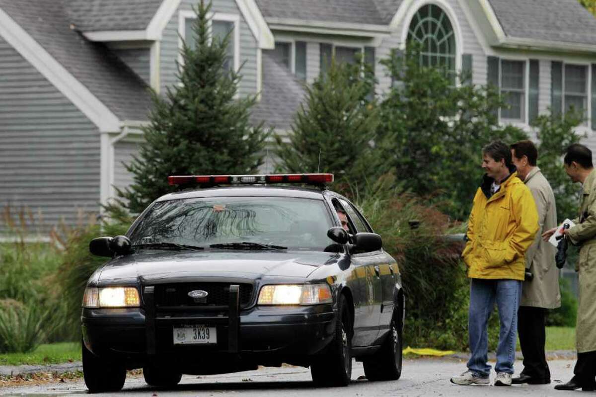 Journalists talk to a New York State trooper in front of the home of Sam and Amy Friedlander in Cross River, Wednesday, Oct. 19, 2011, where four bodies were found Tuesday afternoon. Police say Sam Friedlander, who was in the middle of a divorce, fatally shot his two children and bludgeoned his wife before killing himself in their home. The bodies of Amy and Sam Friedlander and their children Gregory, 8, and Molly, 10, were discovered Tuesday afternoon in the house, hours after their deaths. (AP Photo/Kathy Willens)