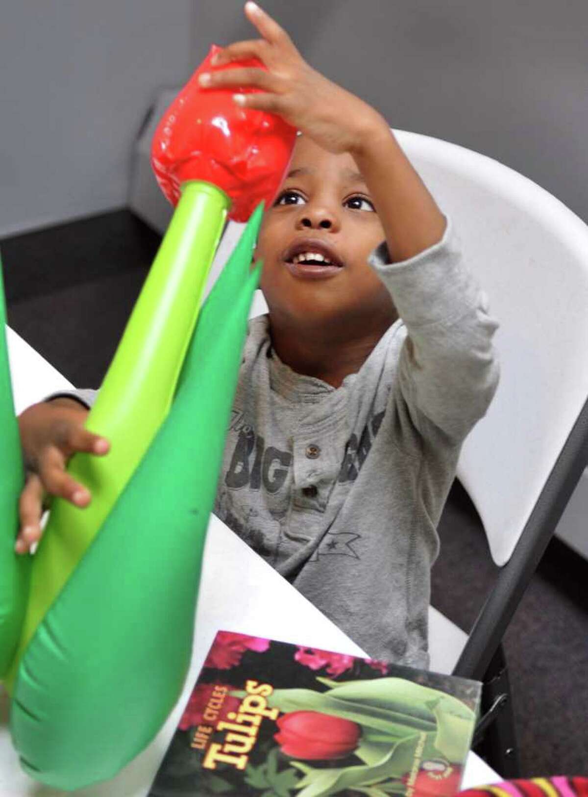 Nasim Sanders-Smith, 4, of Albany with an inflatable tulip during a preschool program about tulips using the STEM model (Science, Technology, Engineering, and Math) at the Albany Heritage Area Visitors Center Thursday Oct. 20, 2011. (John Carl D'Annibale / Times Union)