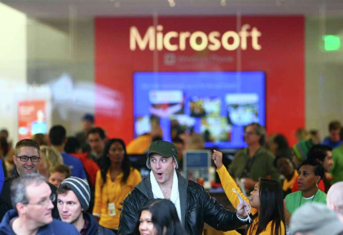 People leave the new Microsoft Store after they secured passes to concerts by The Black Keys and OneRepublic during the opening celebration of the new retail store at University Village on Thursday, October 20, 2011.