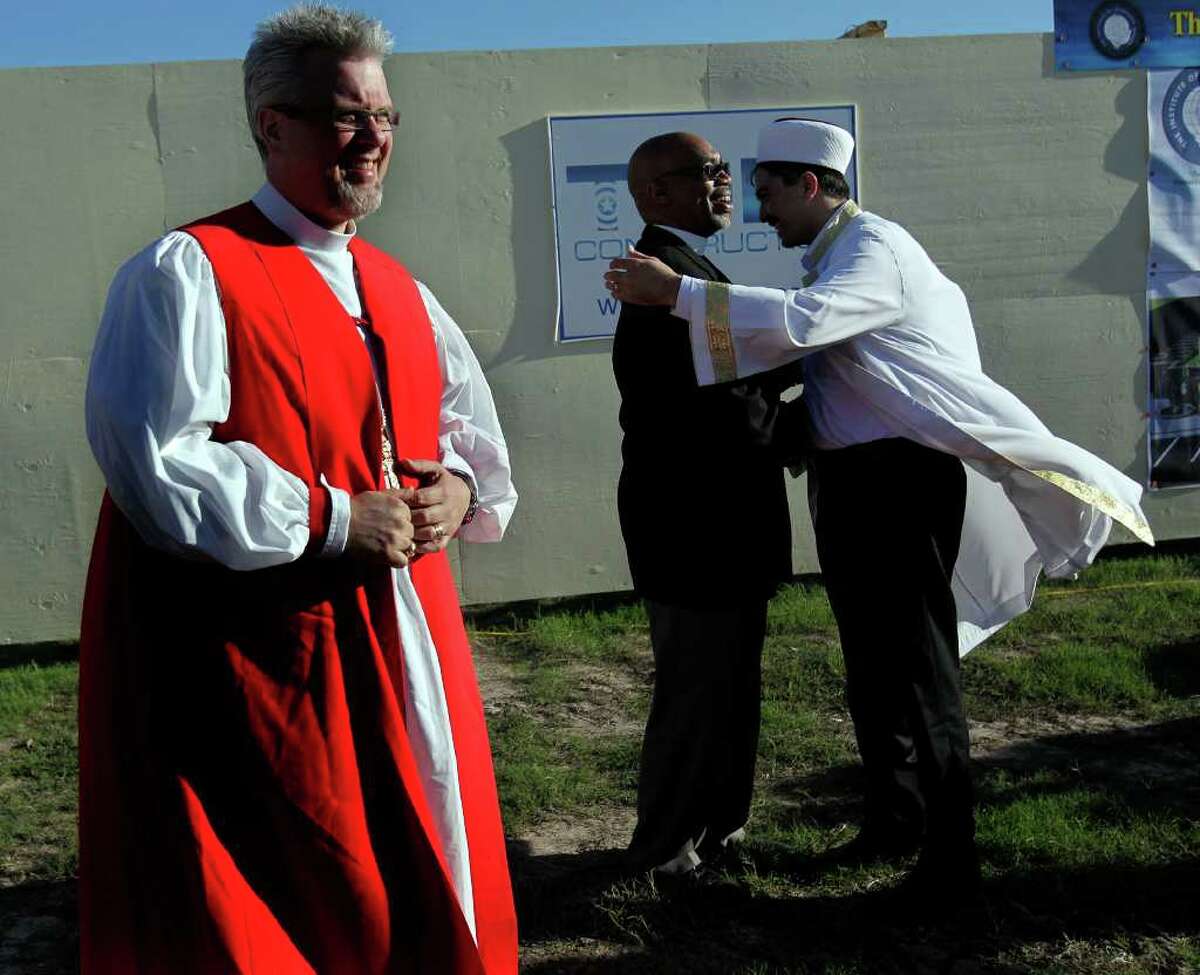 After the groundbreaking for the Interfaith Peace Garden, Imam Mustafa Yigit, right, of Houston Blue Mosque hugs Rev. John Ogletree of the First Metropolitan Church next to The Rt. Rev. C. Andrew Doyle, bishop of the Episcopal Diocese of Texas before more than 200 gathered with Houston area religious and political leaders during a prayer service calling for sensible immigration reform at The Institute of Interfaith Dialog Tuesday, Oct. 18, 2011, in Houston. Imam Mustafa Yigit, Cardinal Daniel DiNardo, Bishop Janice Riggle Huie, and Rabbi Michael Rinehart were a few of the religious leaders in attendance. The prayer service was followed by a series of workshops on human trafficking, work and wages, and pending federal legislation and policy. "We are renewing our commitment to our brothers and sisters," Cardinal Daniel DiNardo said. "The simple religious reason why we are doing this is because human beings are made in the image and likeness of God. No matter who you are. And as leaders we have to keep the issue in front of people. There has to be a prophetic voice." ( Johnny Hanson / Houston Chronicle )