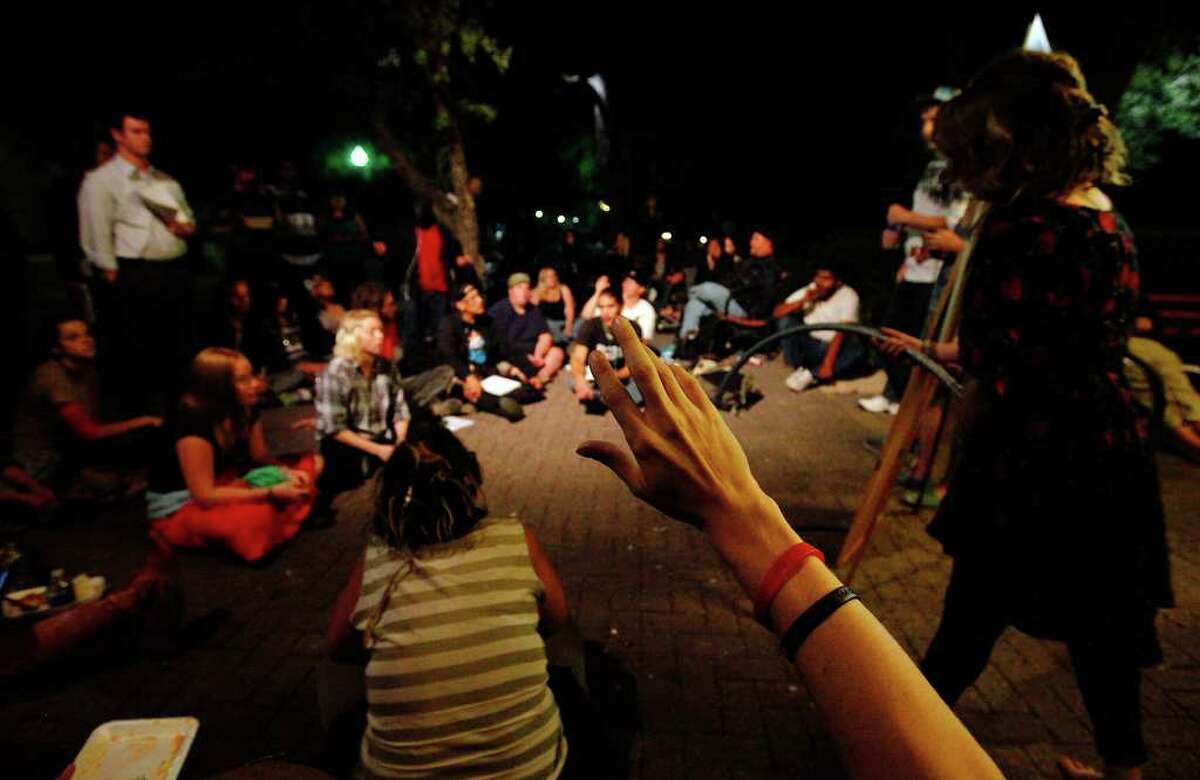 An Occupy SA member raises his hand to ask a question during the group's general assembly meeting on Wednesday, Oct. 19, 2011. The group is going on its second week of their social movement and public outcry. Members have settled at HemiFair Plaza where they have daily meetings and discussions. Once a week, they also have a meditation and drum circle.
