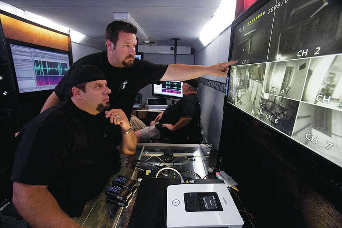 Brothers Brad (front) and Barry Klinge (standing) look at images   inside the Ghost Lab trailer in Chicago. 