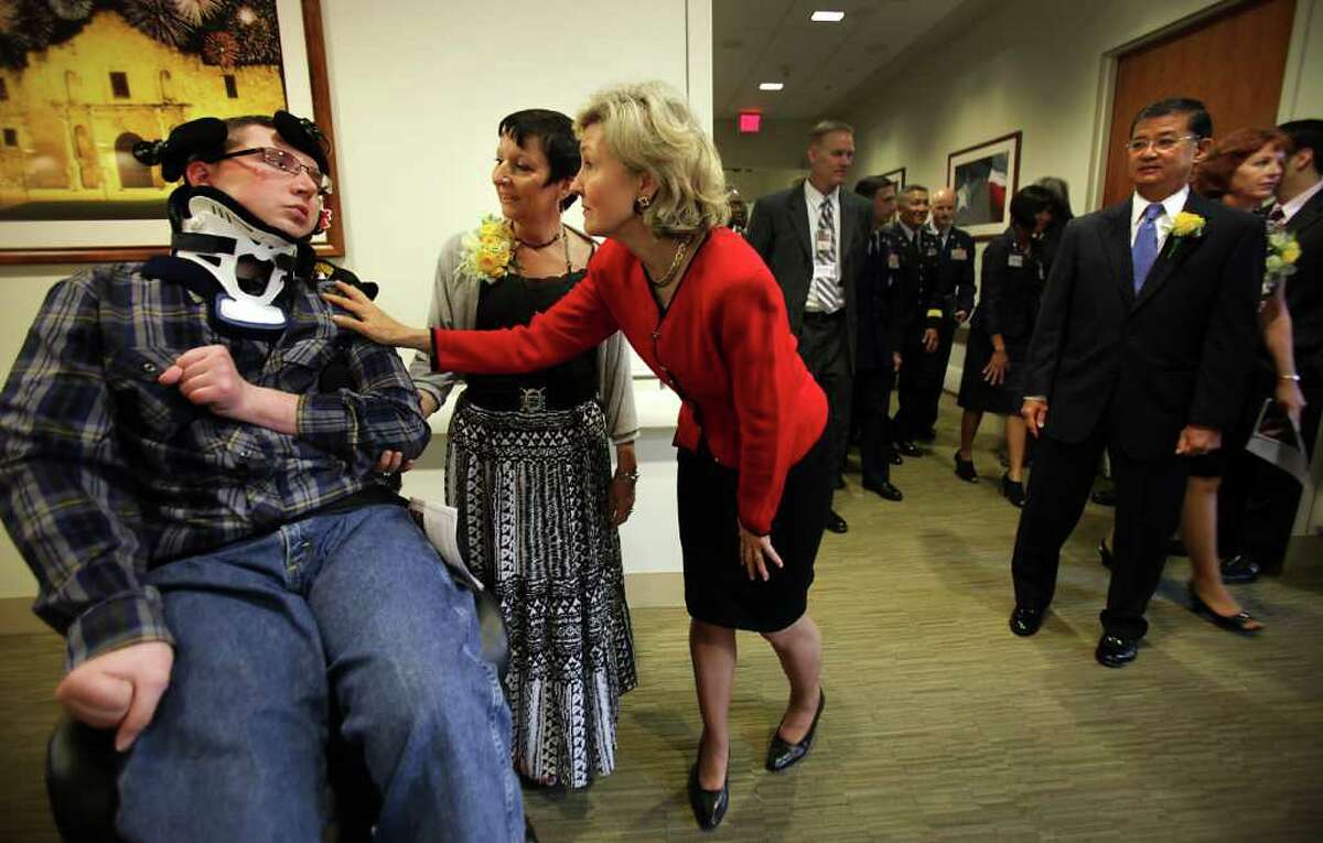 Senator Kay Bailey Hutchison, center, greets U.S. Army Spc. (retired)Chris Harmon 27, left, after she gave her corsage to Chris's mother Cinde Harmon, center left, as Secretary of Veterans Affairs Eric K. Shinseki, right, looks on. The dignitaries were at the dedication ceremony of the Polytrauma Rehabilitation Center which is in the South Texas Veterans Health Care System. Harmon was the victim of a drunk driving accident in September of 2004 when he was home on a three-day pass. Tuesday, Oct. 25, 2011. Photo Bob Owen/rowen@express-news.net