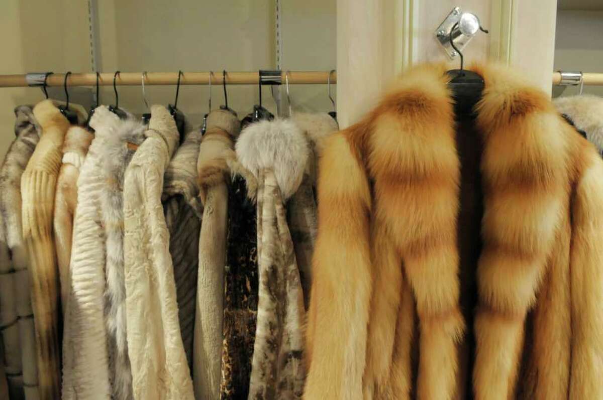 Изделия с мехом. Женщина примеряет шубу. Смоленска можно сдать меховые изделия. Где сдать мех. Много шуб.