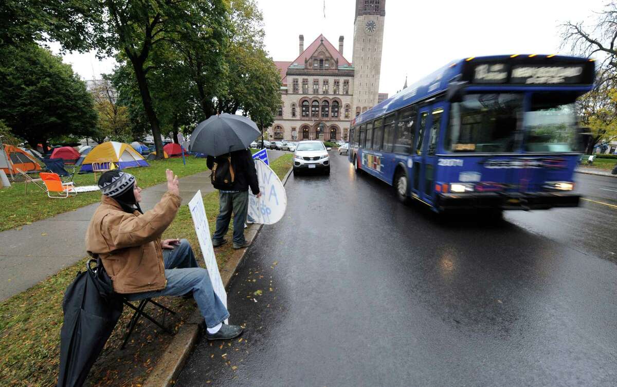 Ray Drake waves to the passersby at the Occupy Albany tent city in Academy Park in Albany, N.Y. October 26, 2011. (Skip Dickstein/Times Union archive)