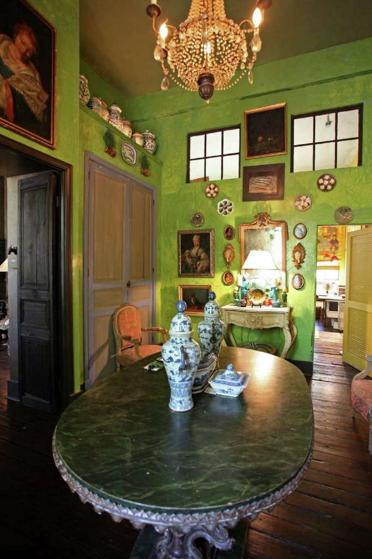Griffith had her son paint the entry sour apple green. She found the green doors trimmed in purple in Los Angeles and had them shipped home and built around them. Art, dishes and pottery are displayed in the entry.