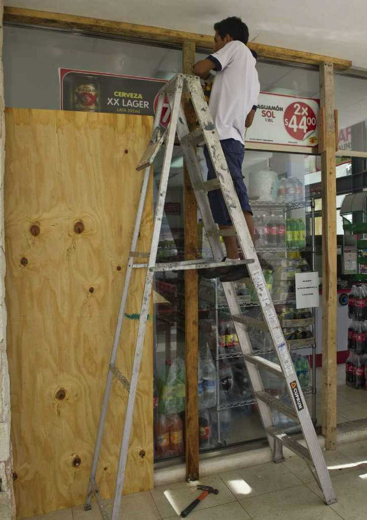 Ronaldo Schemidt : AFP/Getty Images BOARDING UP: Workers in Playa del Carmen cover windows Wednesday as Hurricane Rina targets the Mexican coast.