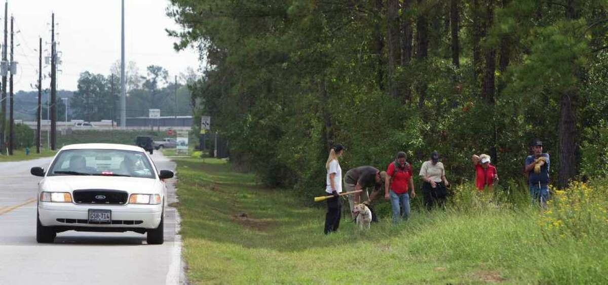 Members of the Montgomery County Search and Rescue team comb a section of woods as the search for Thomas "T. J." Murray continues Thursday, Oct. 27, 2011, in Spring. Murray was last seen leaving a sports bar on Sawdust Road in Montgomery County just after midnight Oct. 19. ( Brett Coomer / Houston Chronicle )