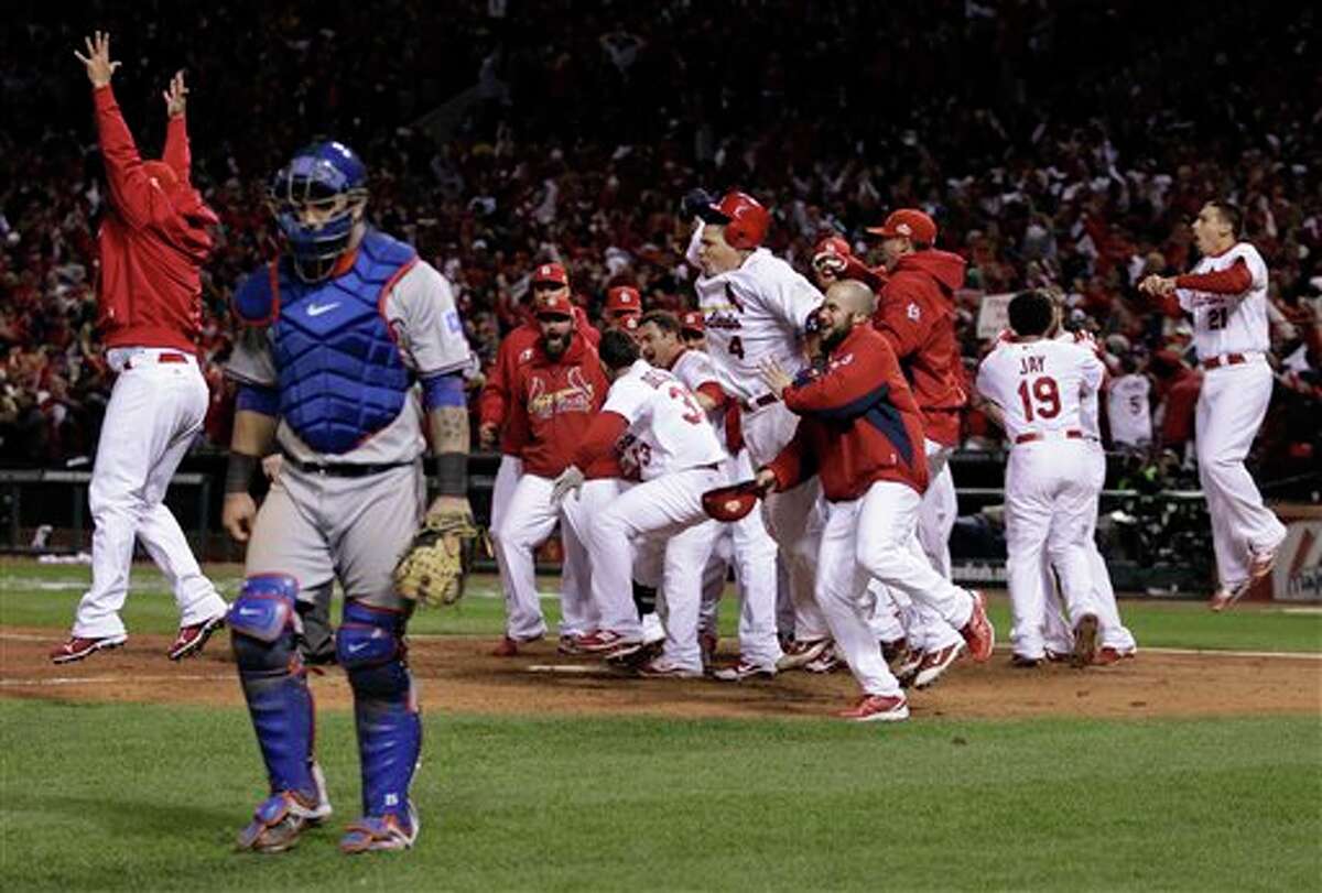 Texas Rangers catcher Mike Napoli walks away as the St. Louis Cardinals celebrate after David Freese hit a walk-off home run during the 11th inning of Game 6 of baseball's World Series Thursday, Oct. 27, 2011, in St. Louis. (AP Photo/Matt Slocum)
