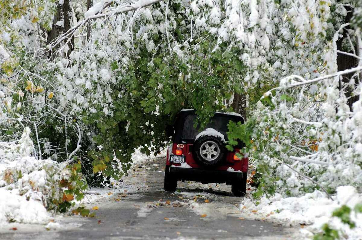 A car attempts to drive along Mountain Road in Cornwall, N.Y., Sunday, October 30. 2011. Millions of people from Maine to Maryland are without power after an unseasonably early nor'easter dumped heavy, wet snow over the weekend on a region more used to gaping at leaves in October than shoveling snow. (AP Photo/Lee Ferris).