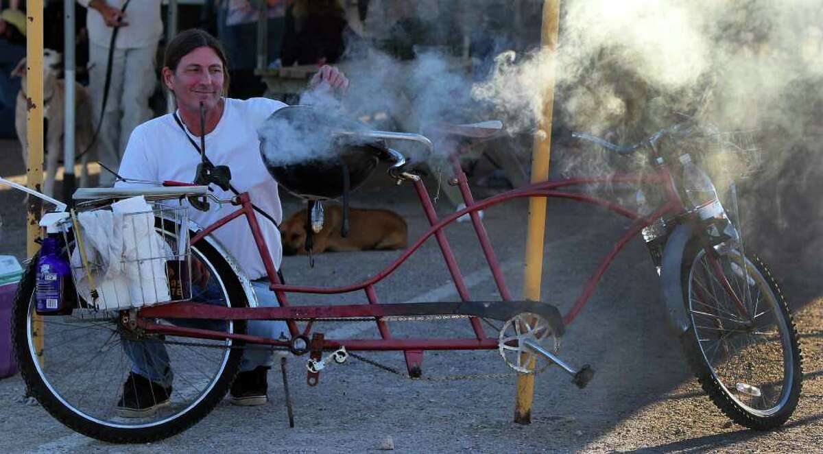 Scott Mitchell grills hamburgers on his Royal River Bar-B-Cruiser, which used to be a tandem bike.