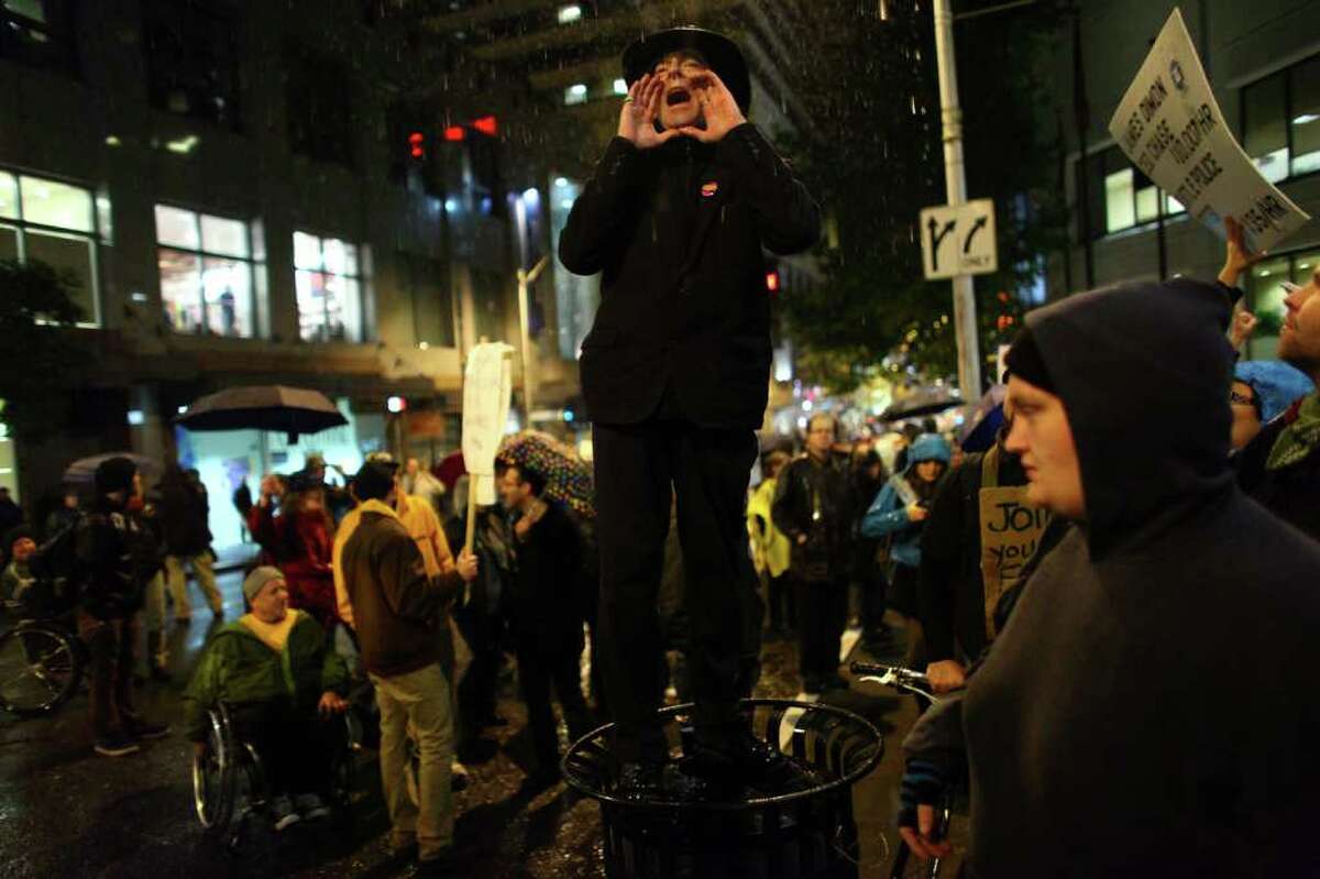 An organizer calls for protesters to gather at the doors of the Sheraton Hotel during an Occupy Seattle protest where Chase Bank CEO Jamie Dimon was speaking on Wednesday, Nov. 2, 2011. A few hundred people tried to block the doors to the hotel during an event.