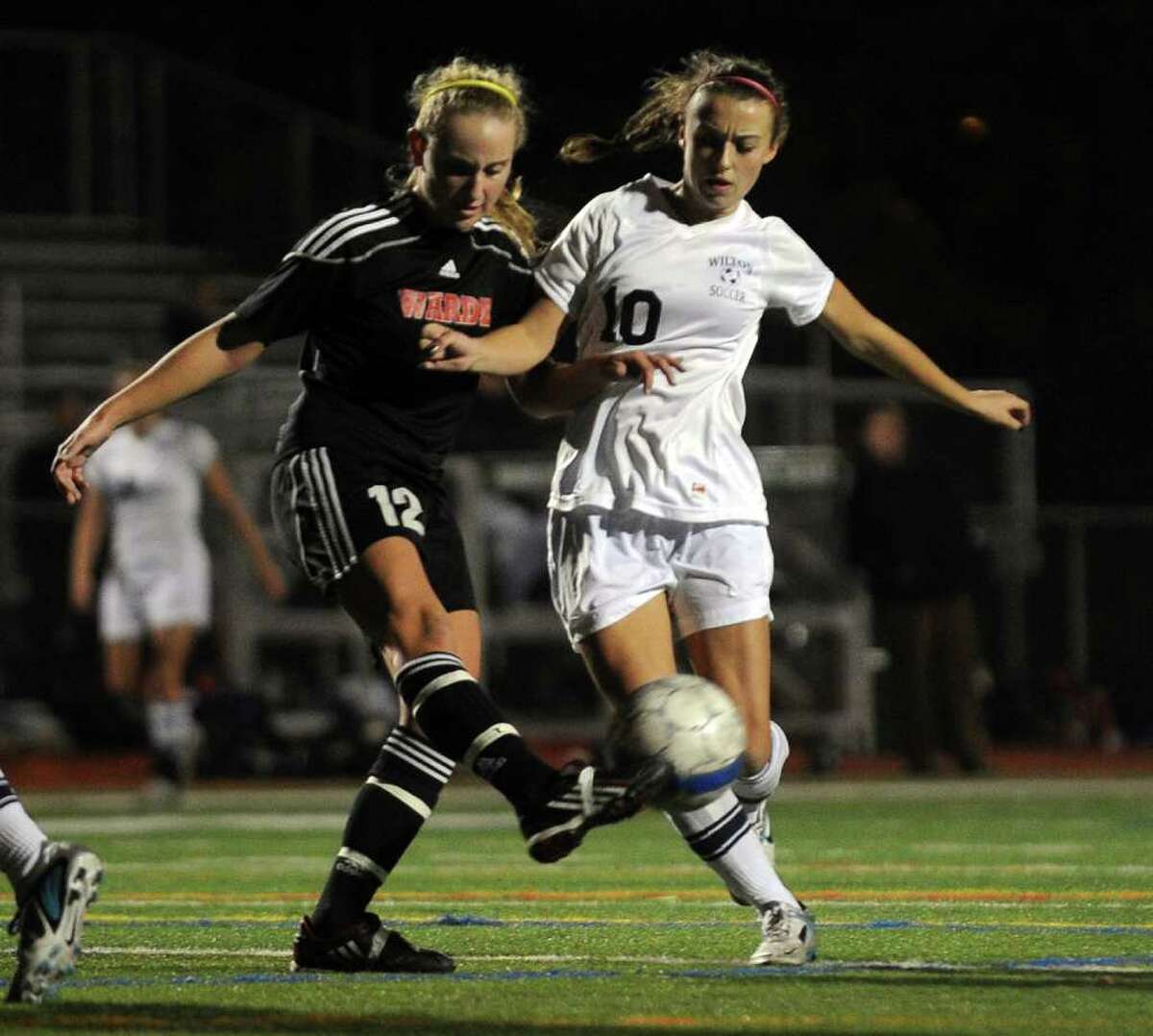 Fairfield Warde's #12 Maggie Allen, left, gets to the ball before Wilton's #10 Lindsay Knutson, during FCIAC girls' soccer semi-finals action in Norwalk, Conn. on Thursday November 3, 2011.