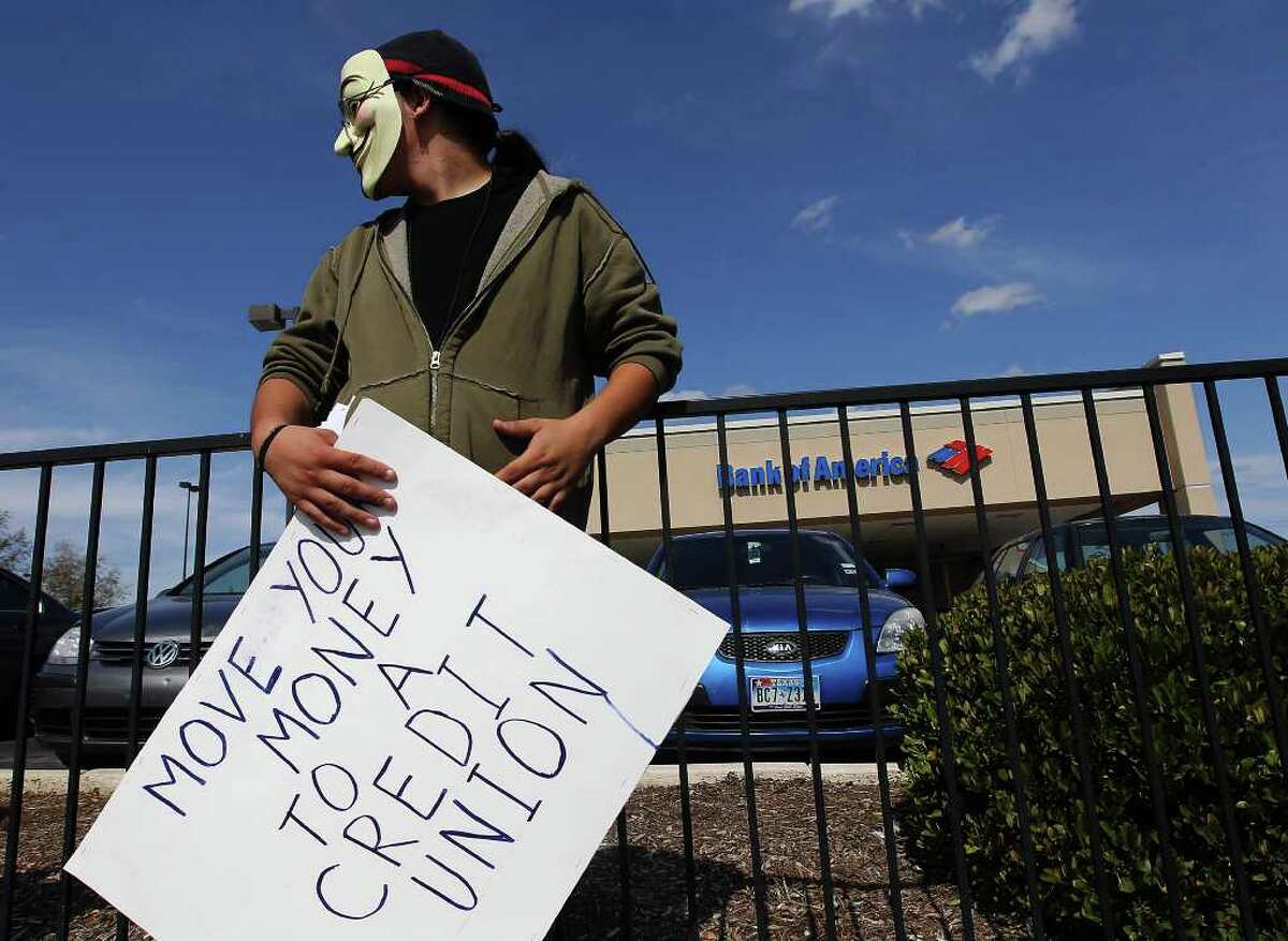 An Occupy San Antonio activist stands near a Bank of America branch office off Vance Jackson during a recent protest in conjunction with members of MoveOn.org San Antonio on Saturday, Nov. 5, 2011. Later, the Occupy SA group marched in the downtown area. Kin Man Hui/kmhui@express-news.net