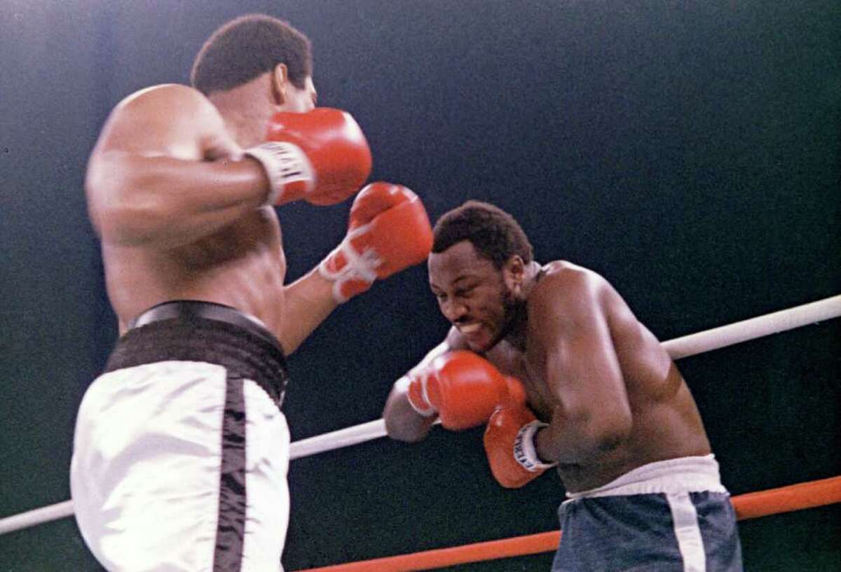 FILE - In this Oct. 1, 1975, file photo, heavyweight boxer Joe Frazier grimaces after Muhammad Ali, left, landed a blow to Frazier's head during their boxing bout in Manila, the Philippines. Ali won the fight after Frazier's manager stopped the fight in the 14th round. Frazier, the former heavyweight champion who handed Ali his first defeat yet had to live forever in his shadow, has died after a brief final fight with liver cancer. He was 67. The family issued a release confirming the boxer's death on Monday night, Nov. 7, 2011.