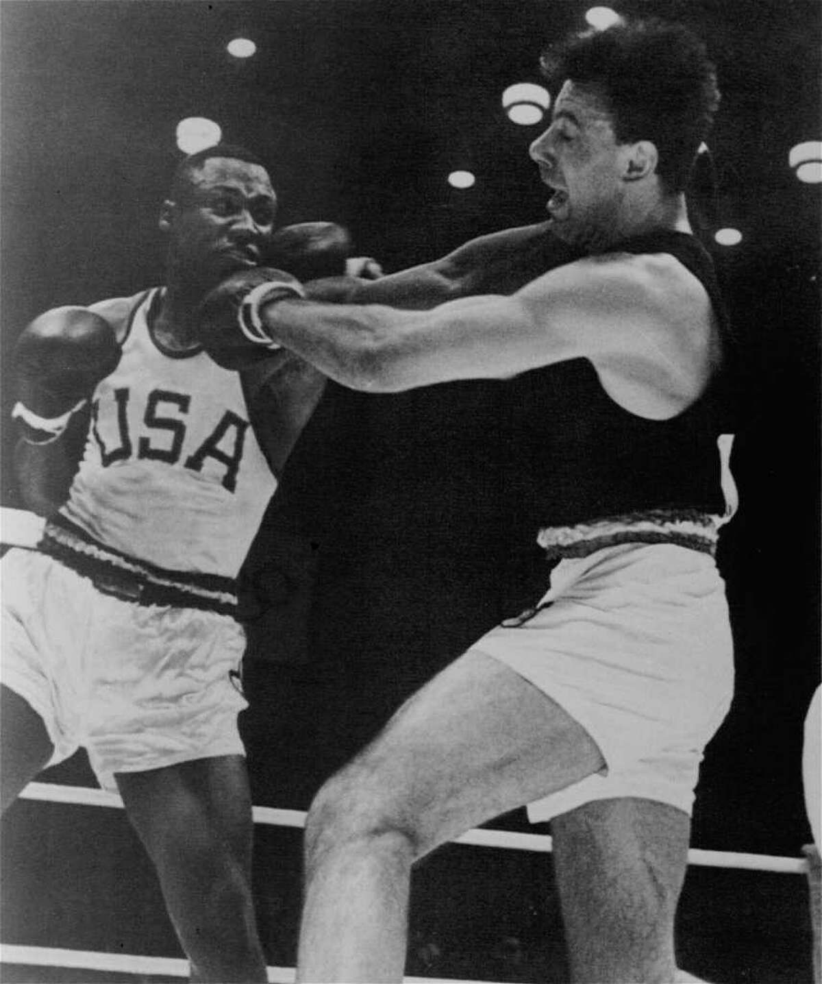 Frazier, left, throws a left to the head of Germany's Hans Huber in their Olympic title bout on Oct. 23, 1964 in Tokyo.