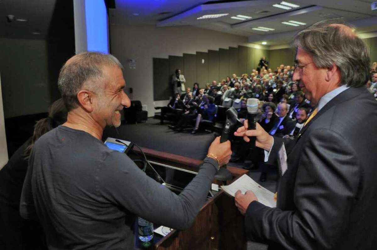 Dr. Alain E. Kaloyeros, Senior Vice President and Chief Executive Officer of the College of Nanoscale Science and Engineering, left, accepts the microphone from David M. Buicko, Chief Operating Officer of The Galesi Group and Chair of the CEG Board of Governors, right, before giving his keynote speech at the CEG Annual Meeting & 25th Anniversary at Albany Nanotech on Wednesday Nov. 9, 2011 in Albany, NY. (Philip Kamrass / Times Union )