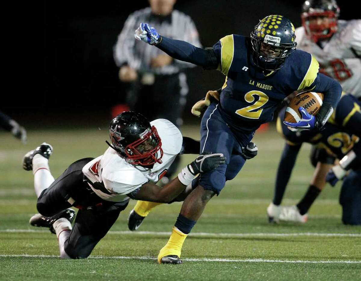 KAREN WARREN: CHRONICLE TAGGING ALONG: La Marque's Tim Wright, right, gains yardage despite the best efforts of Terry defender Manuel Mancilla during the first half Thursday night.